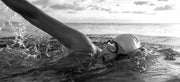 An athlete side breathing while swimming in open water