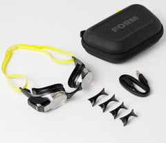 Assorted set of swim goggle accessories laid out, including straps and mounts, labeled with the FORM logo.