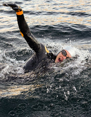 Man swimming front crawl in open water with swim tracker in his goggles