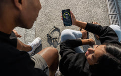 Two swimmers sharing their swim app on smart phone screen