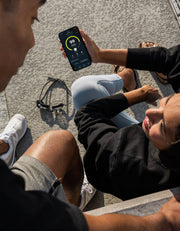 Two swimmers sharing their swim app on smart phone screen